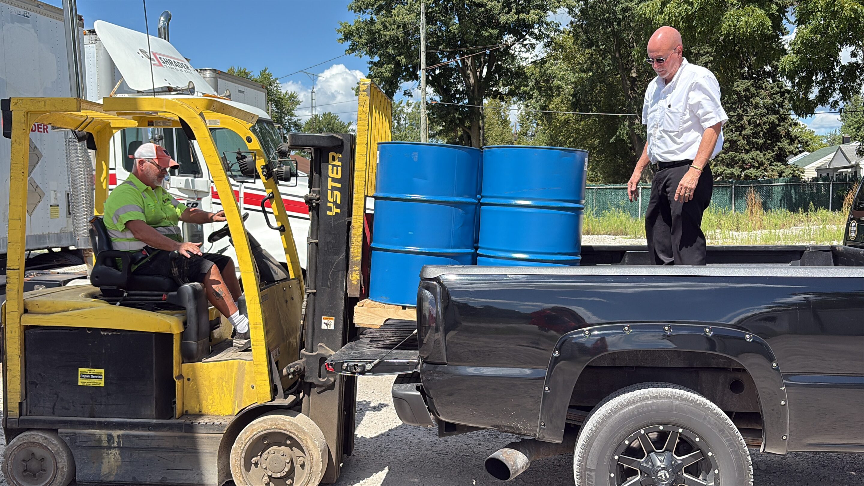 Jim Muncy, Shrader Tire & Oil sales rep, standing beside oil drums at a customer location in Ohio