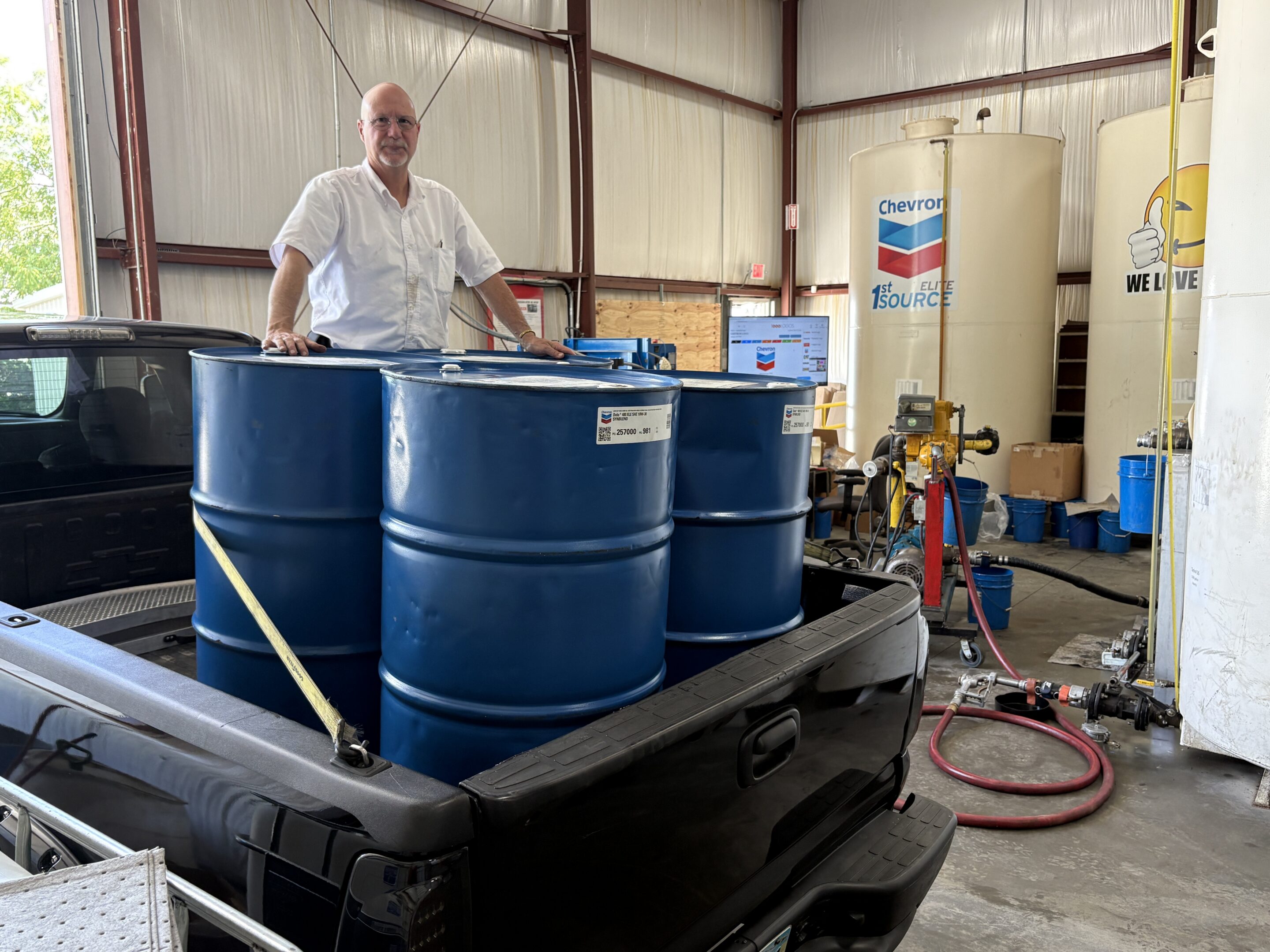 Jim Muncy next to Chevron oil drums at a Shrader Tire & Oil facility in Ohio